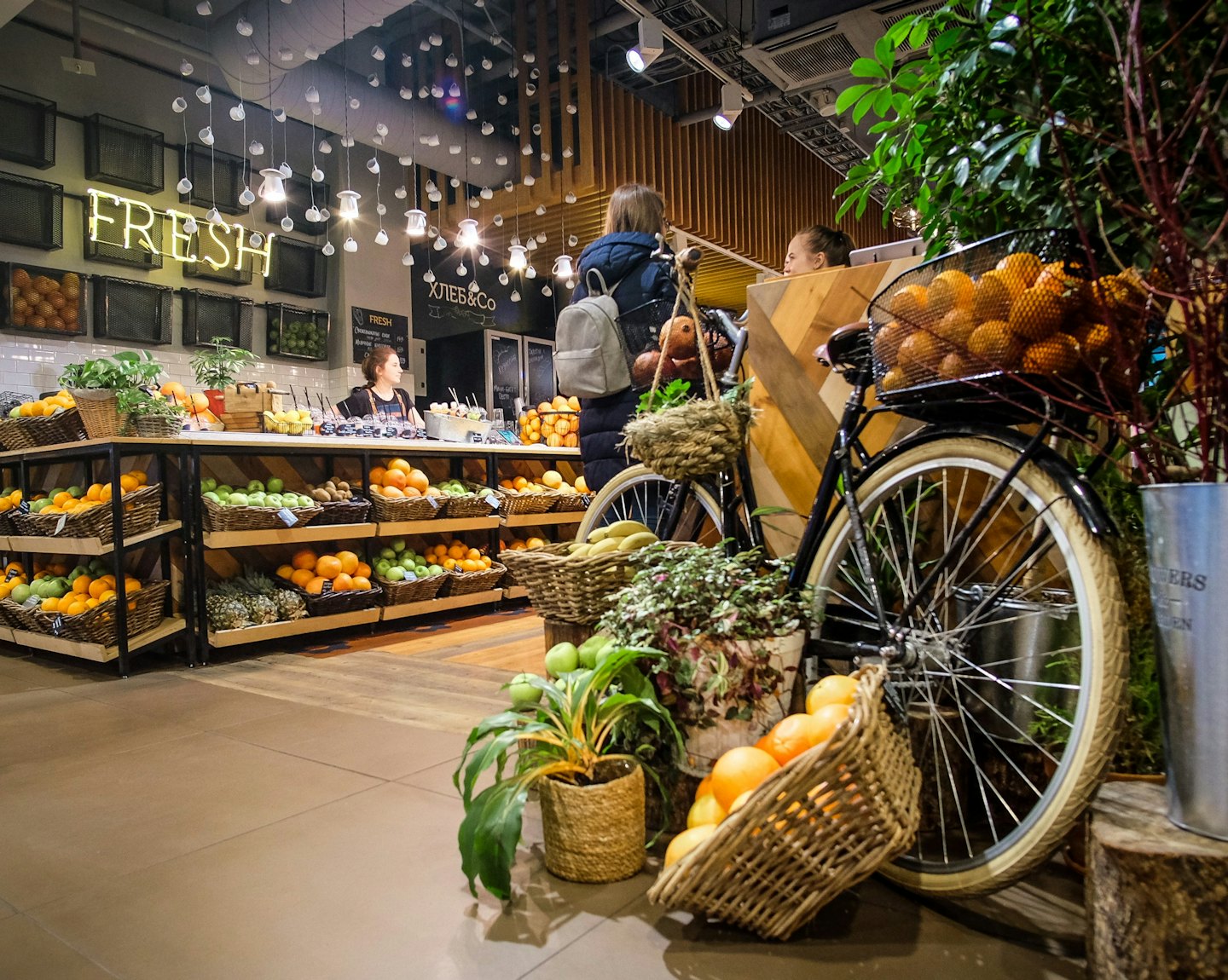 Clienti e personale interagiscono in un negozio di alimentari con prodotti freschi.