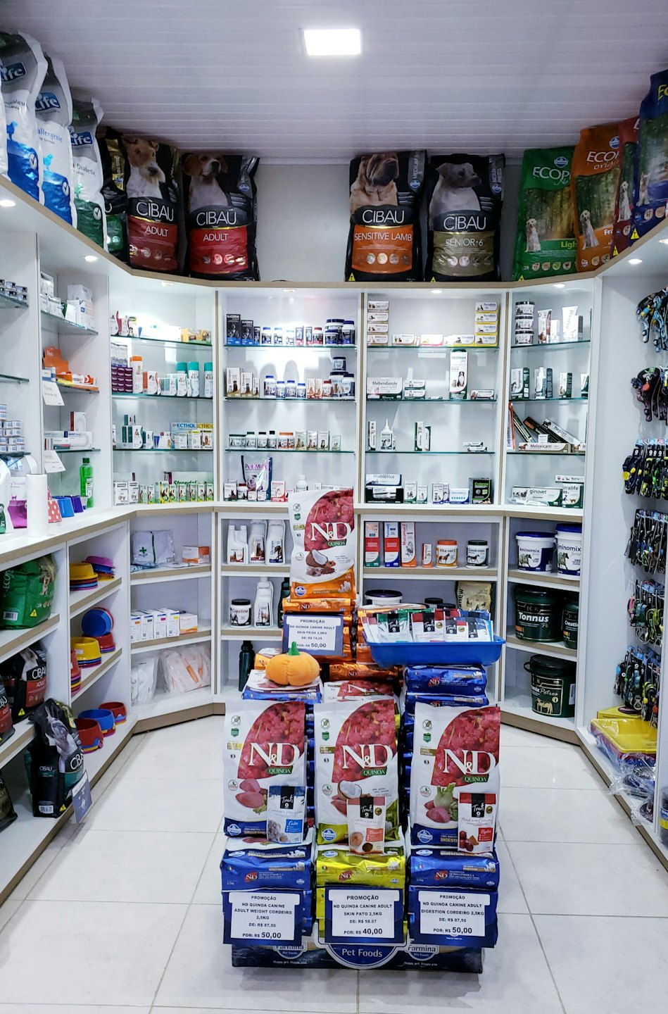 Interno di un negozio di animali luminoso con scaffali di forniture per animali.
